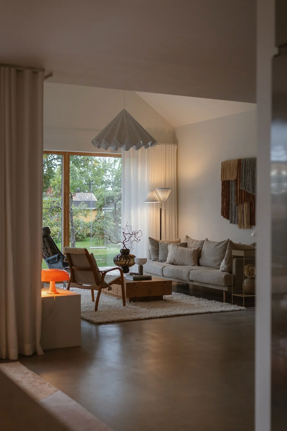 In the living room at Applaudden, an orange lamp glows, capturing the interior design trends of 2026.