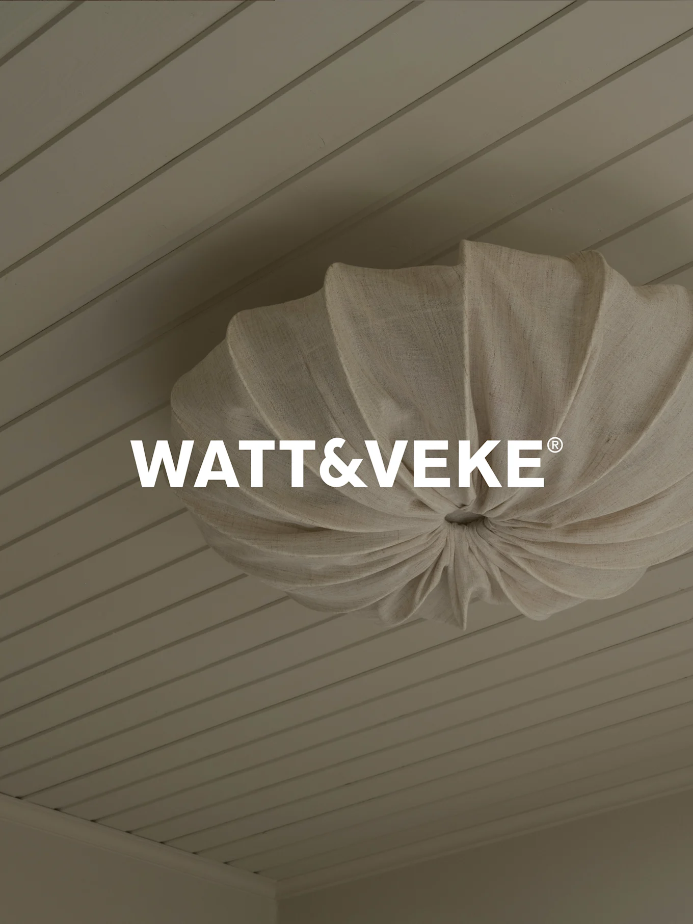 WATT&VEKE® logo over a pleated, natural fabric ceiling light on a light wood plank ceiling.