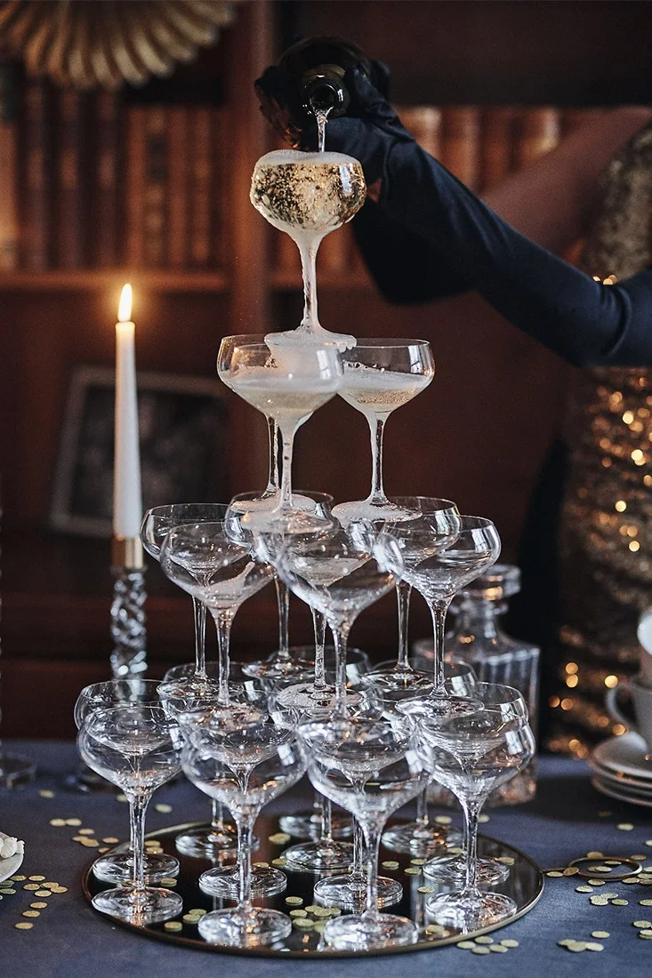 Discover how to build a champagne tower for your New Year's party with coupe glasses from Orrefors & Spiegelau for an atmospheric new year table setting.