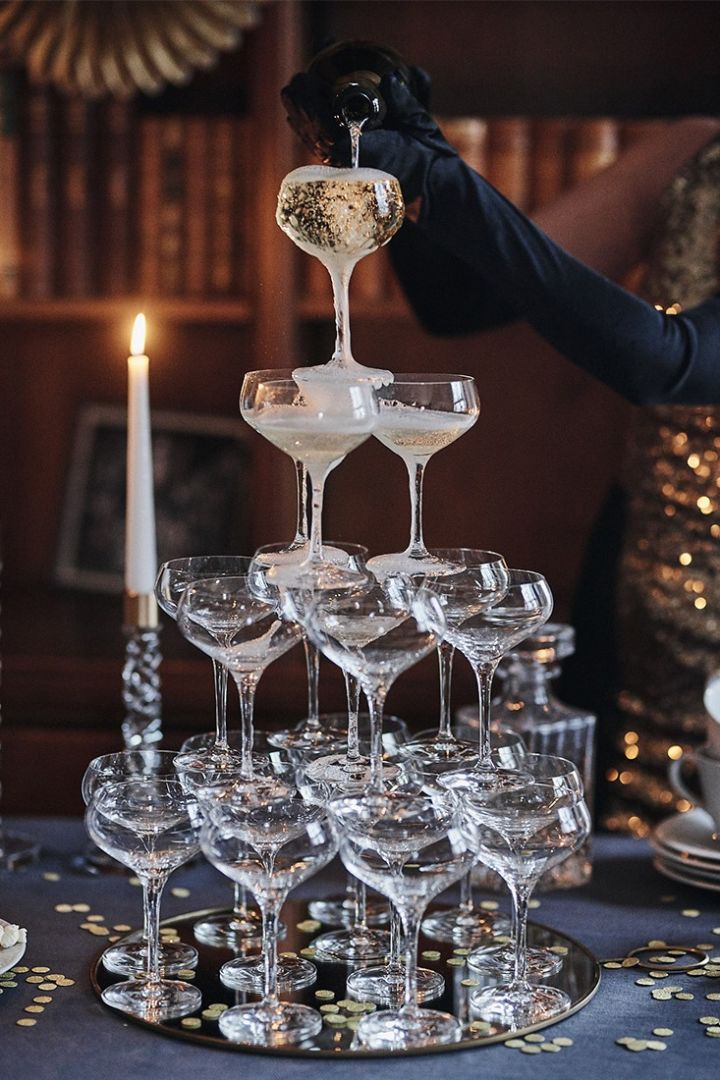 Discover how to build a champagne tower for your New Year's party with coupe glasses from Orrefors & Spiegelau for an atmospheric new year table setting. 