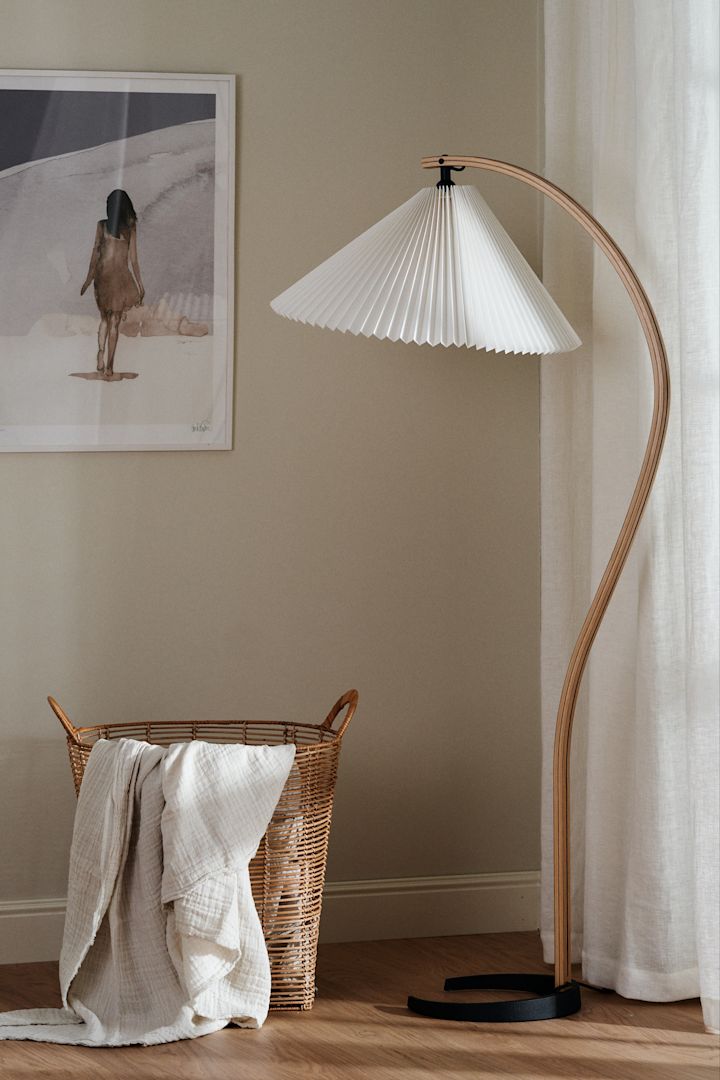 The interior design trends for spring 2023 offer retro-style pleated lamps, where we like to decorate with the trendy floor lamp from Gubi with a white pleated lampshade.