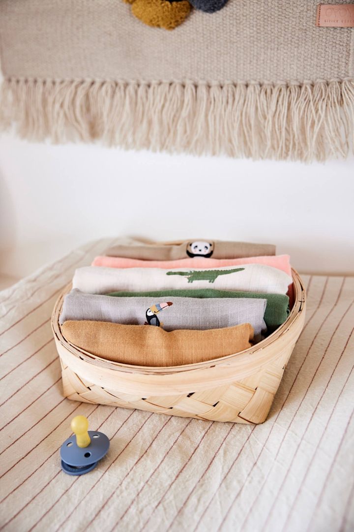 Muslin blankets are a safe bet when it comes to baby shower gift ideas. Here are blankets from OYOY in different colours in a basket.