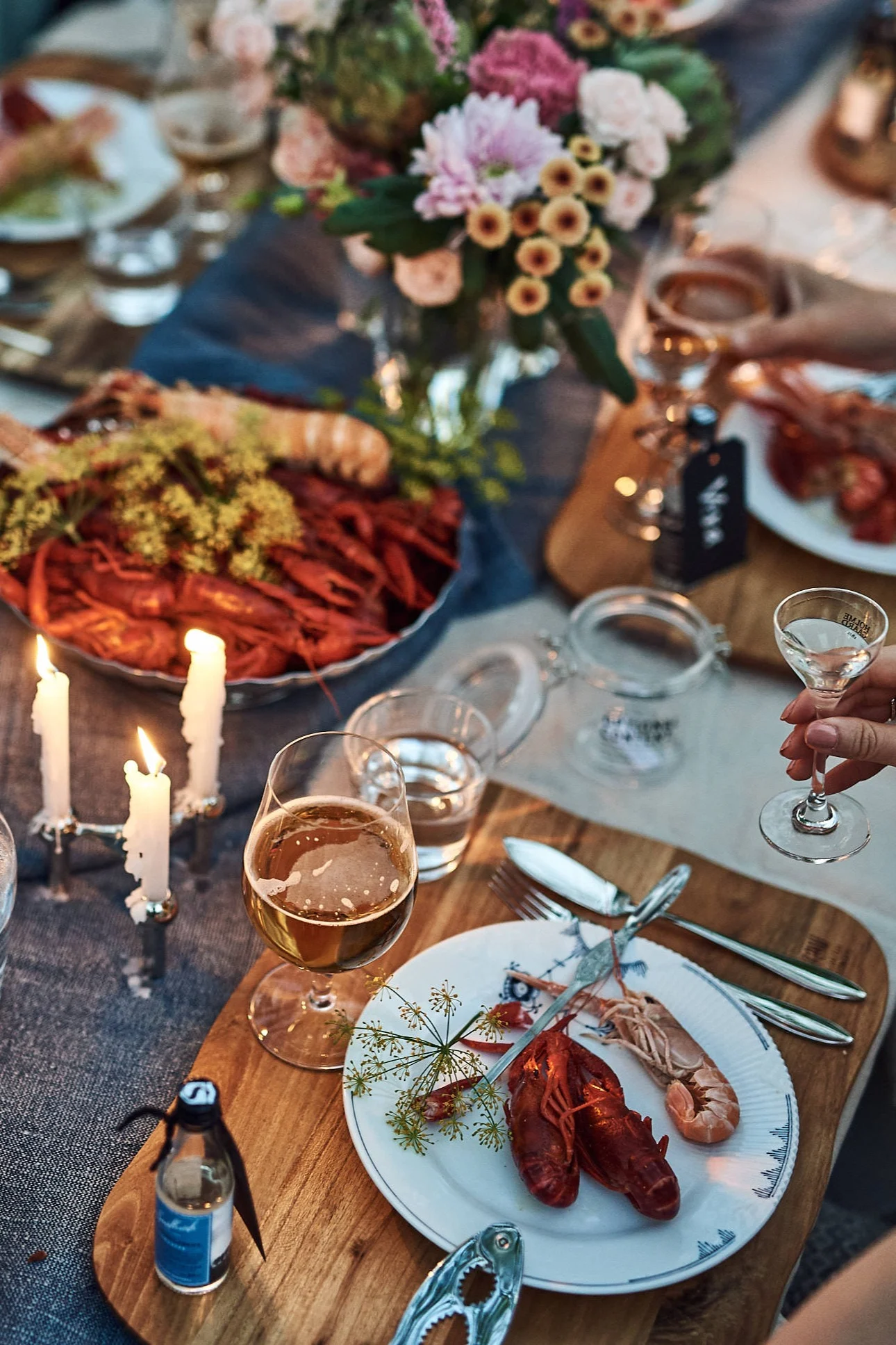 A Swedish crayfish party with a table decorated with blue and white plates, candles and of course plenty of crayfish. 