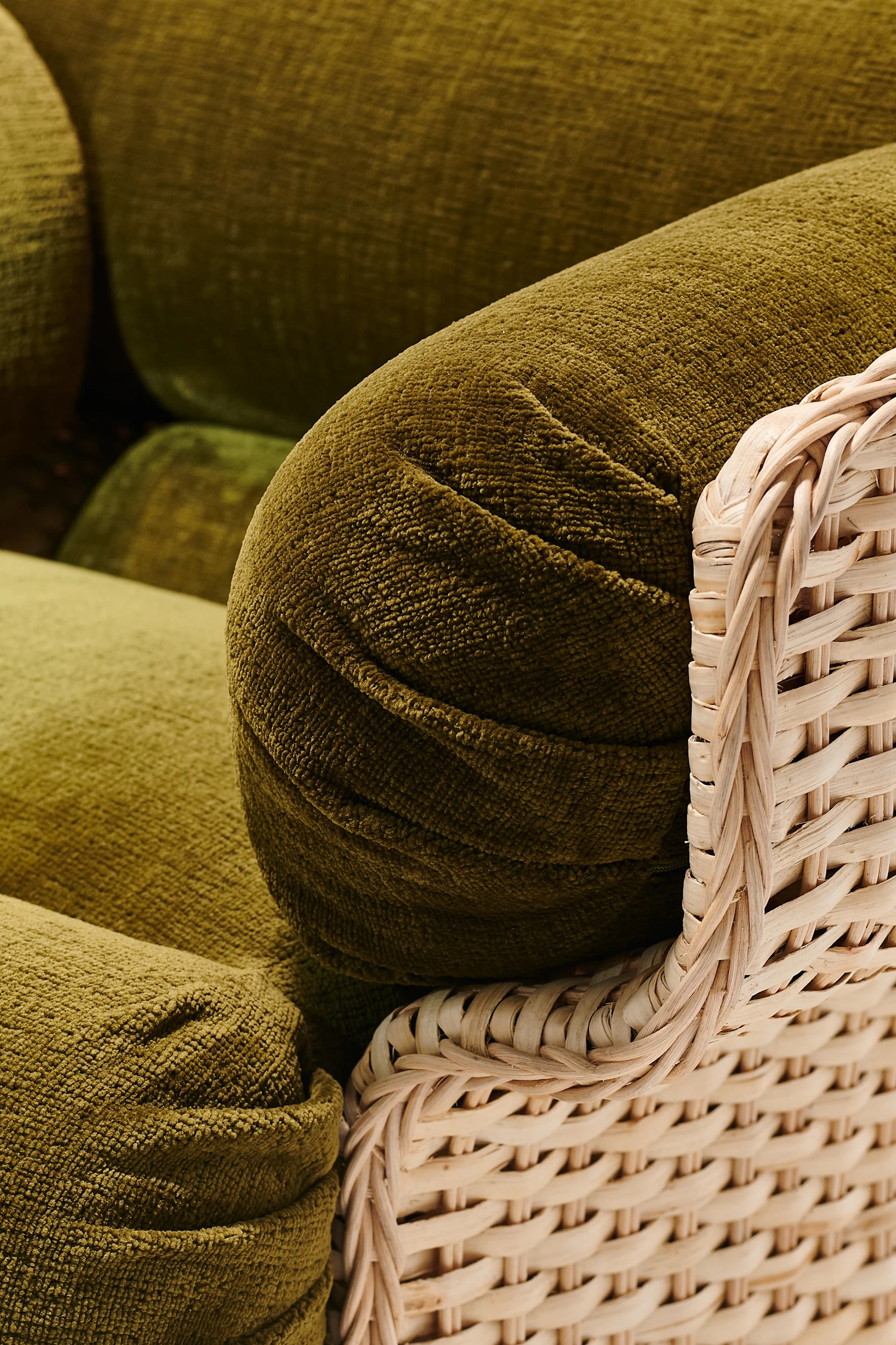 An olive-green armchair with a bohemian feel that reflects the interior design trends of 2026.