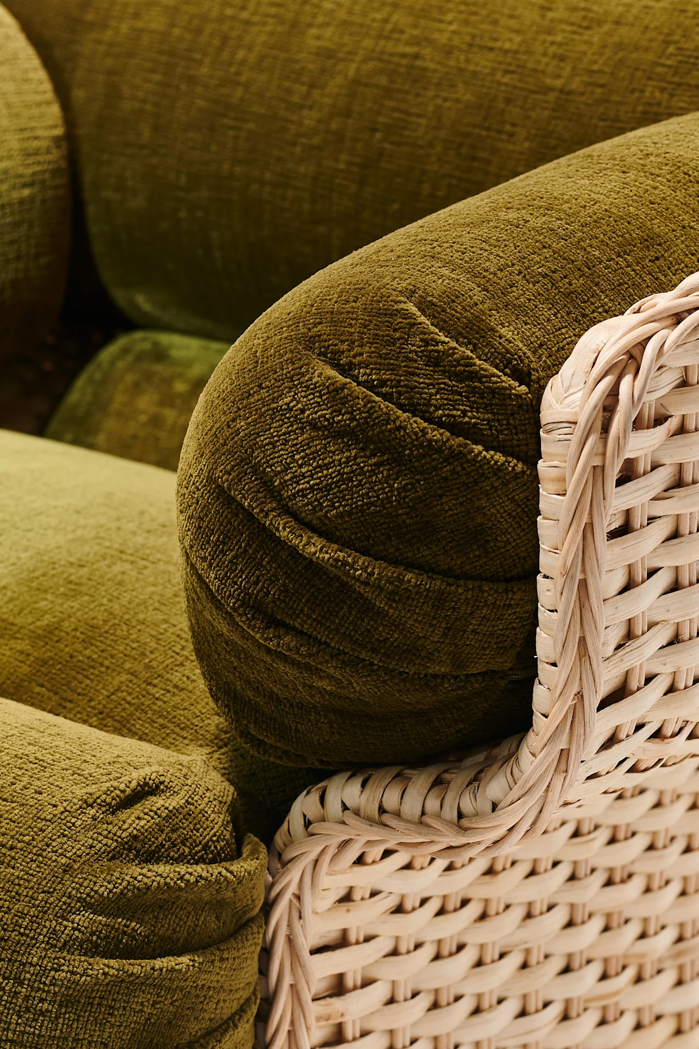 An olive-green armchair with a bohemian feel that reflects the interior design trends of 2026.