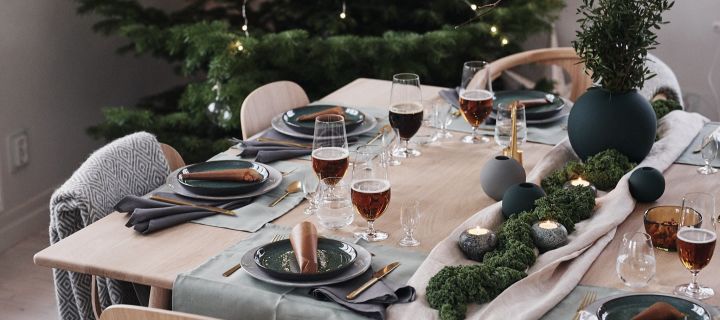 A green decorated Christmas table with kale and stylish dishes
