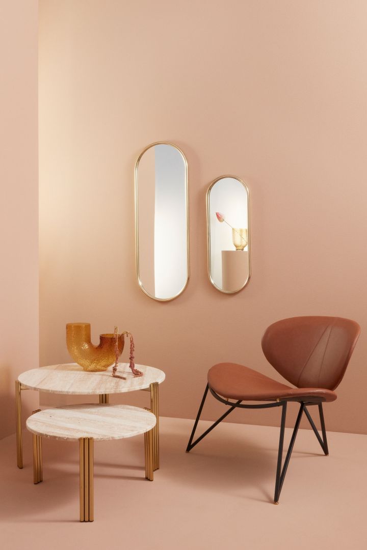 A stylish living room in tones of peach with marble and leather, incorporating many of the Scandinavian interior design trends for 2023.