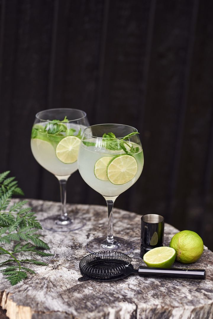 Refreshing summer drinks - a Gin & Tonic garnished with lime and mint served in a classic G&T glass from Orrefors.  