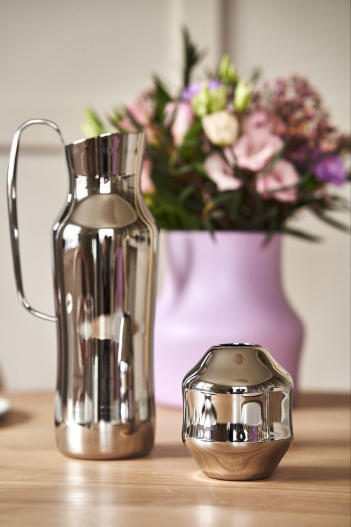 A close up of the polished stainless-steel water jug and the mini Dorotea vase designed by Monica Förster for Gense. 