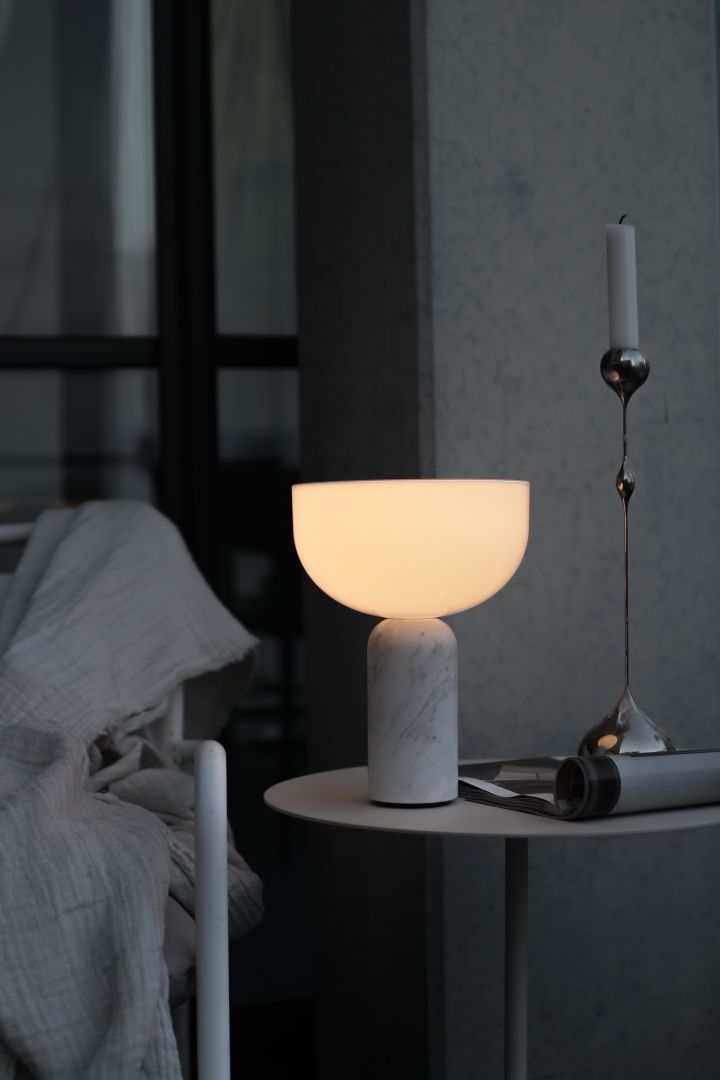 The Kizu portable lamp illuminated on a bedside table makes a great Christmas gift idea for anyone.