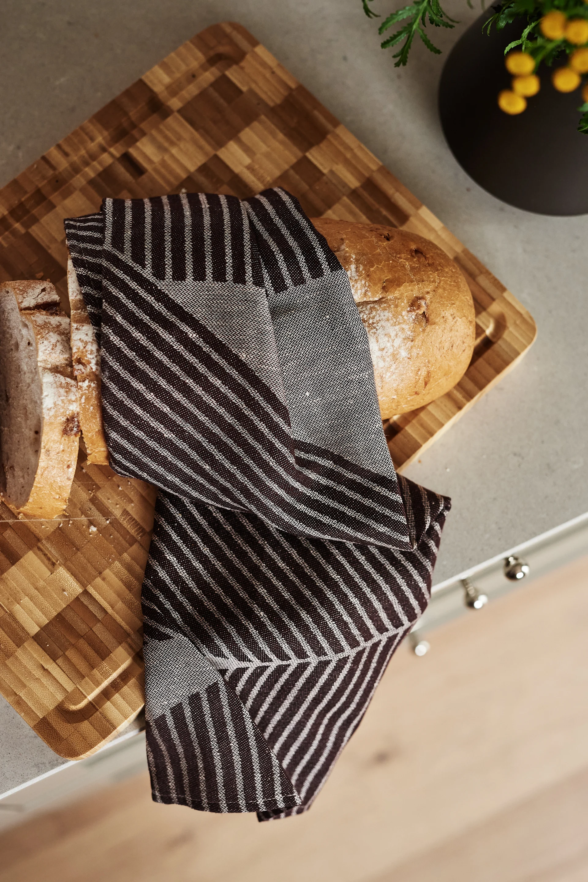 Renew your kitchen with 11 practical and stylish kitchen accessories for easier cooking - here you see the stylish Stripes kitchen towel from NJRD in brown and white.