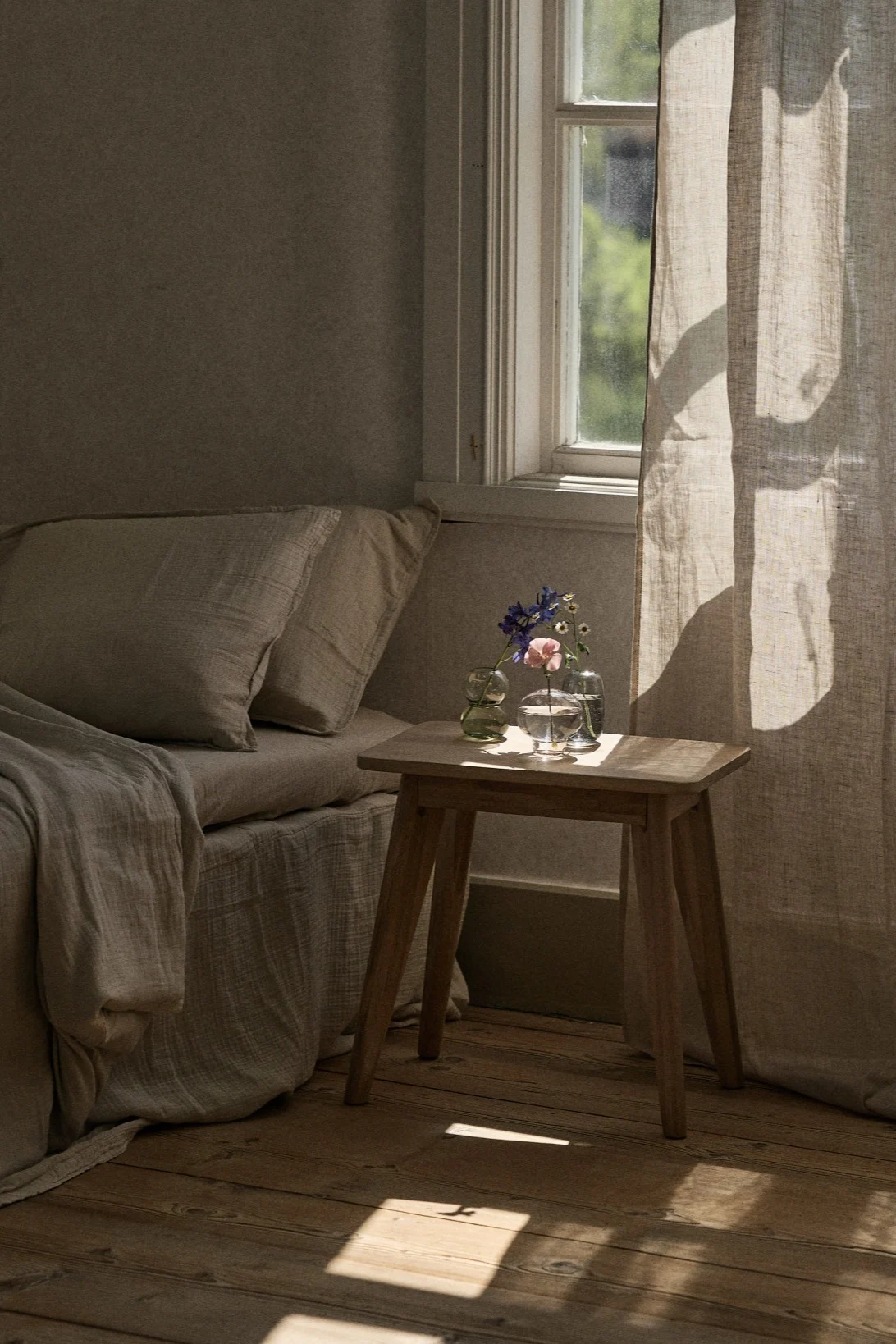 Mini Midsummer vases from Orrefors placed in a group on the bedside table. 