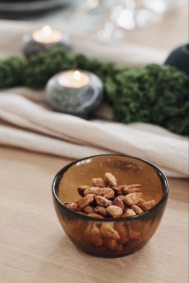 On the table is an amber-colored glass bowl from Bitz with candied almonds.