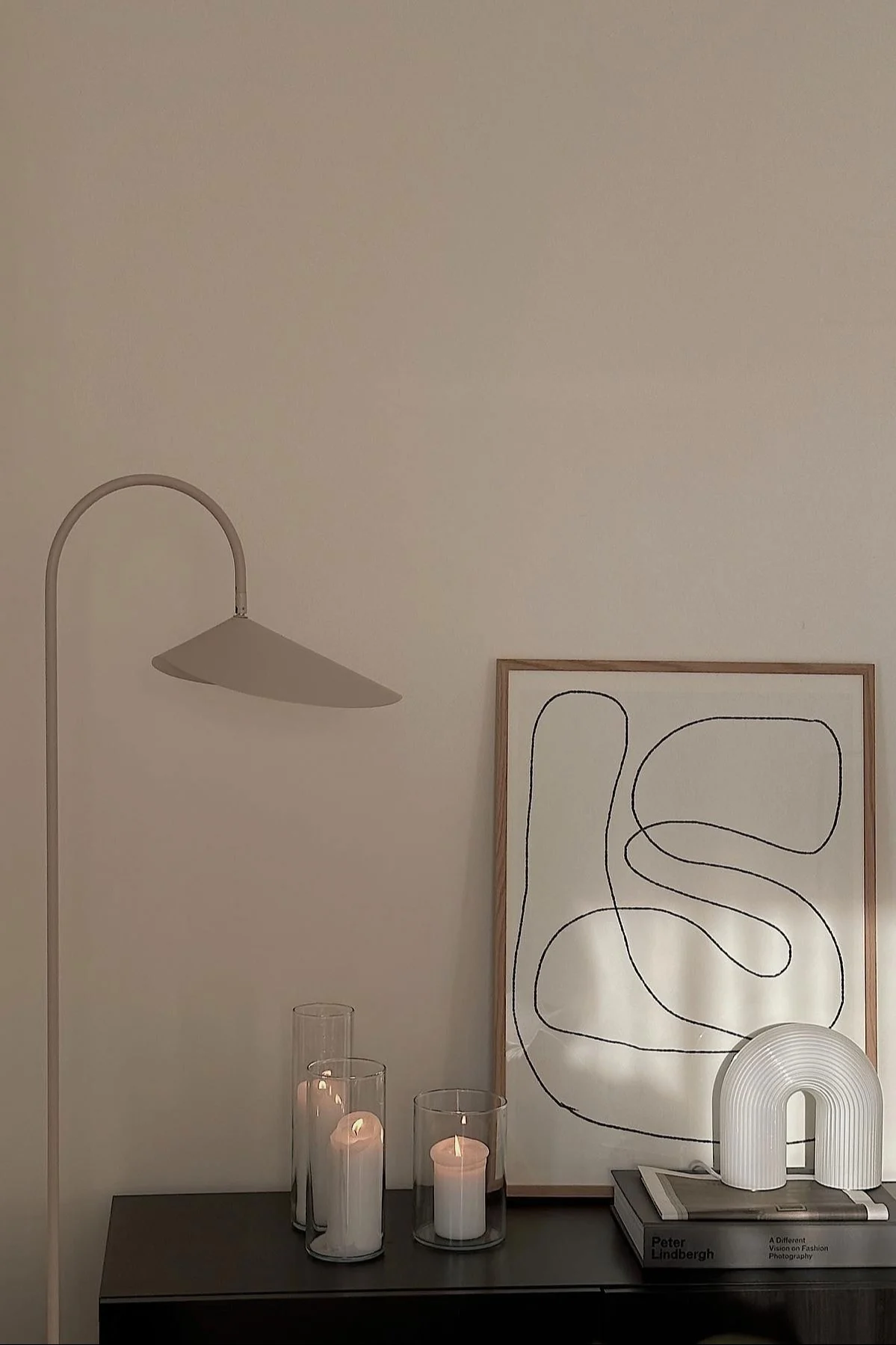 The chest of drawers by @helenas.hem, decorated with candles, a picture, the rounded Vuelta table lamp, next to it stands the Arum floor lamp.