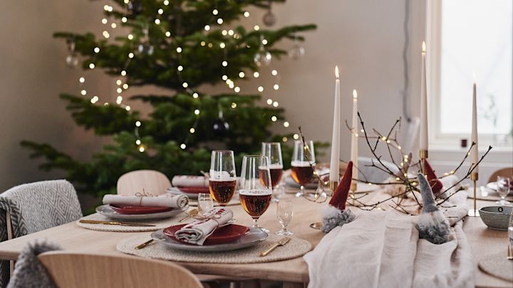 A beautiful Christmas table decoration in red and adorable Santa Clauses made of wool.