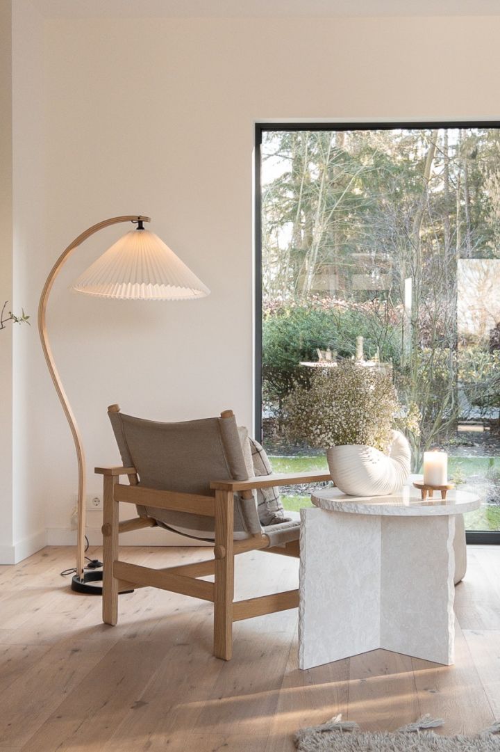 Play with natural light in your Scandinavian home. Here you see a curved floor lamp from Gubi and the Mineral side table from ferm Living. 