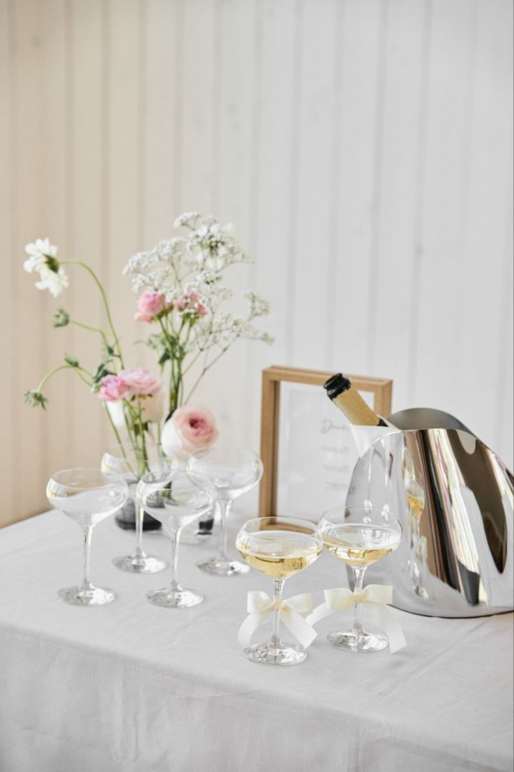 This unique wedding idea is ideal for outdoor weddings. Here you see a drink station with a wine cooler and a set of coupe glasses from Orrefors. 
