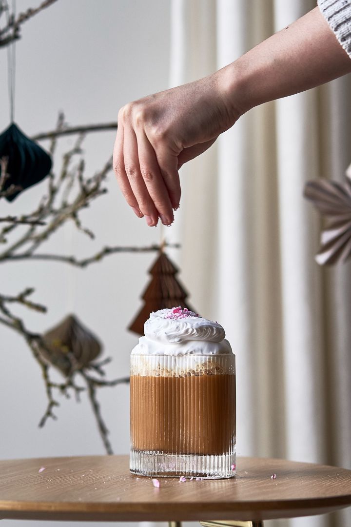 Offer your friends and family a simple Christmas cocktail this year. Here you see a coffee cocktail garnished with whipped cream and candy cane in the Ripe glass from Muubs. 