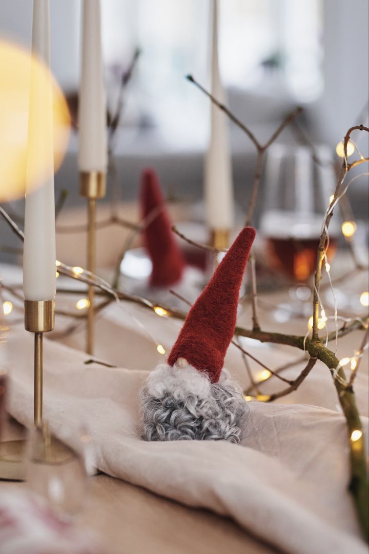 The woolen Santa Claus and the brass candlesticks become wonderful decorations that spread a contemplative mood on the Christmas table.