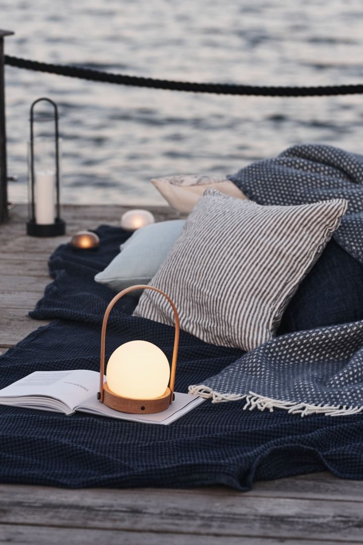 An atmospheric picnic by the sea with the cordless table lamp, Carrie from Menu. 