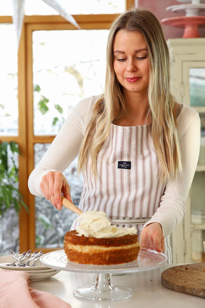 Baka med Frida for the New Year - 3 festive chocolate desserts. Here, Frida Skattberg spreads the tasty cream with a spatula and the cake that stands on the Iittala Kastehelmi cake plate.