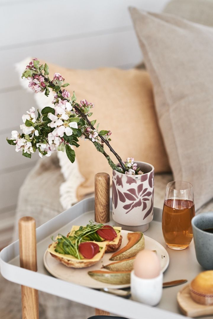 A flowering apple twig is placed in a small cable vase from Kähler, which spreads an extra atmosphere at the breakfast served on the bed.