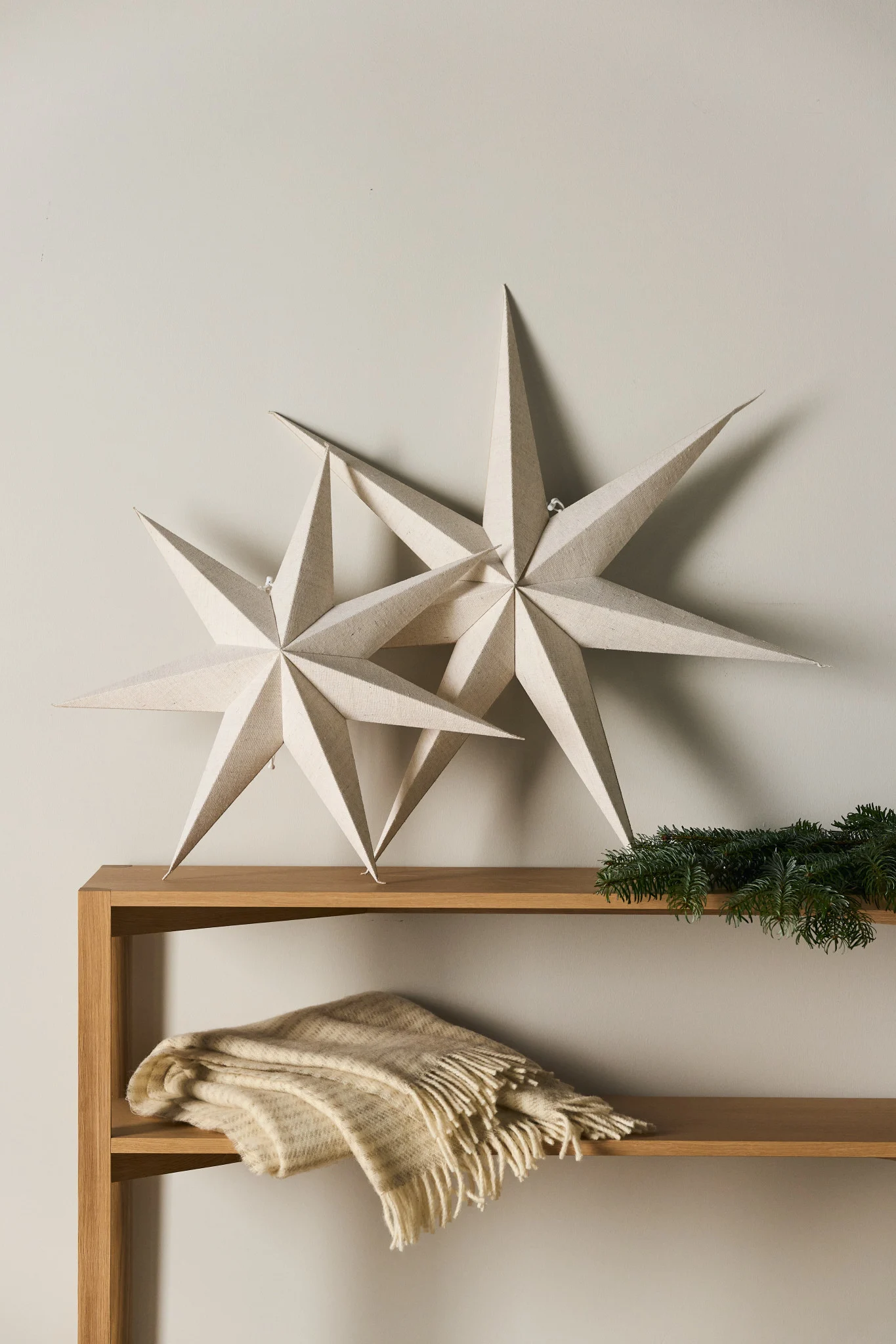 Minimalist Christmas decor with paper Christmas stars hanging from the ceiling of a home.