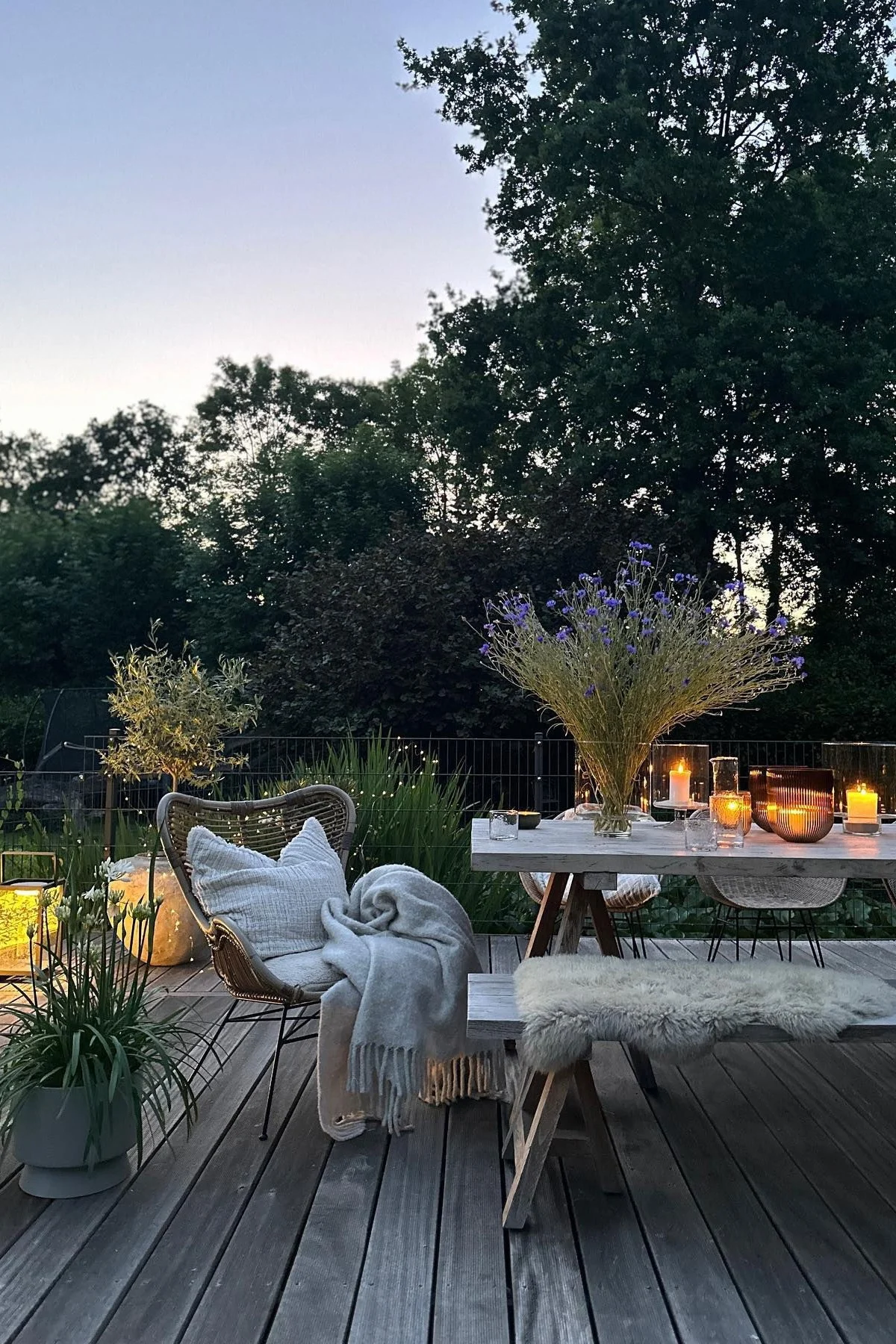 A cosy patio like this one from @stillers.home is characterised by lots of plants, cosy textiles and numerous candles or lanterns.