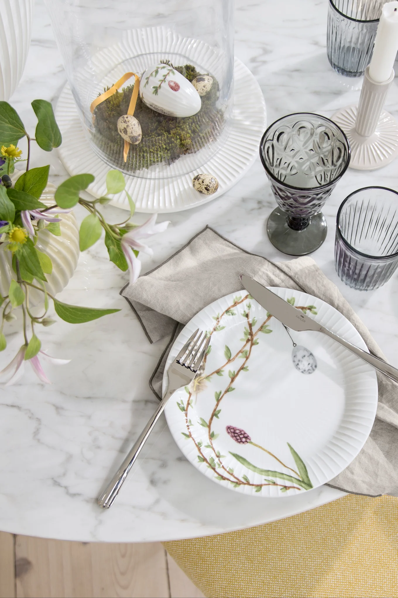 Easter decoration for the table: The Hammershøi Easter plate from Kähler, decorated with Easter motifs, stands on a table set for Easter.