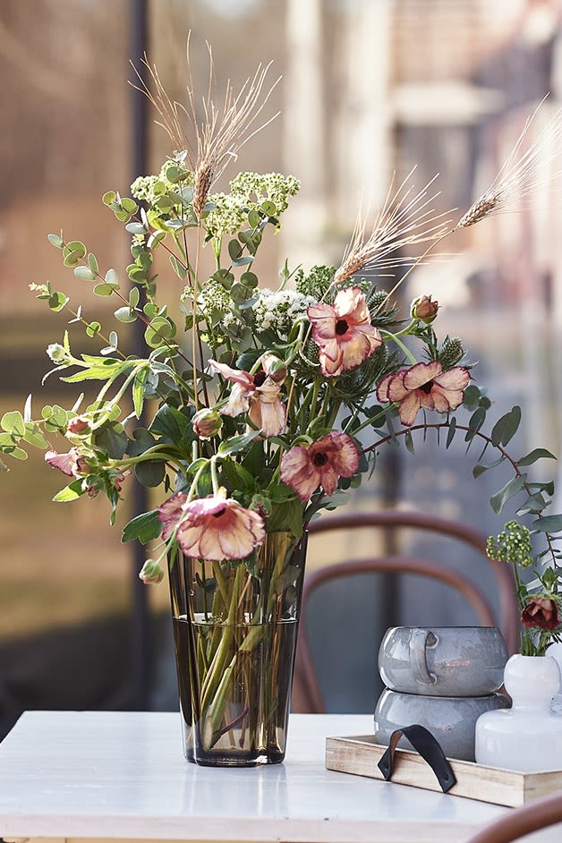 The straight tall Aalto vase from Iittala in a brown coloured glass with a bouquet of flowers from Blombruket. 
